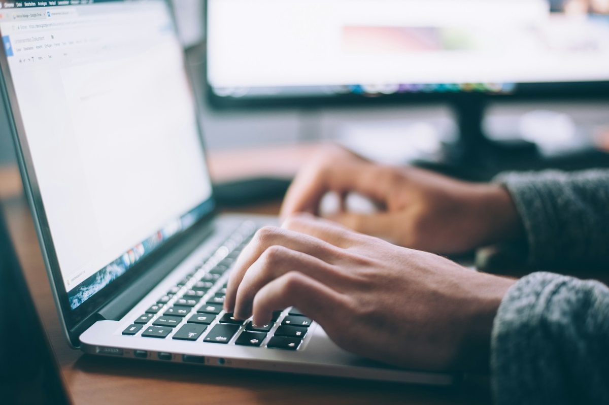 Close-up of hands typing on a laptop